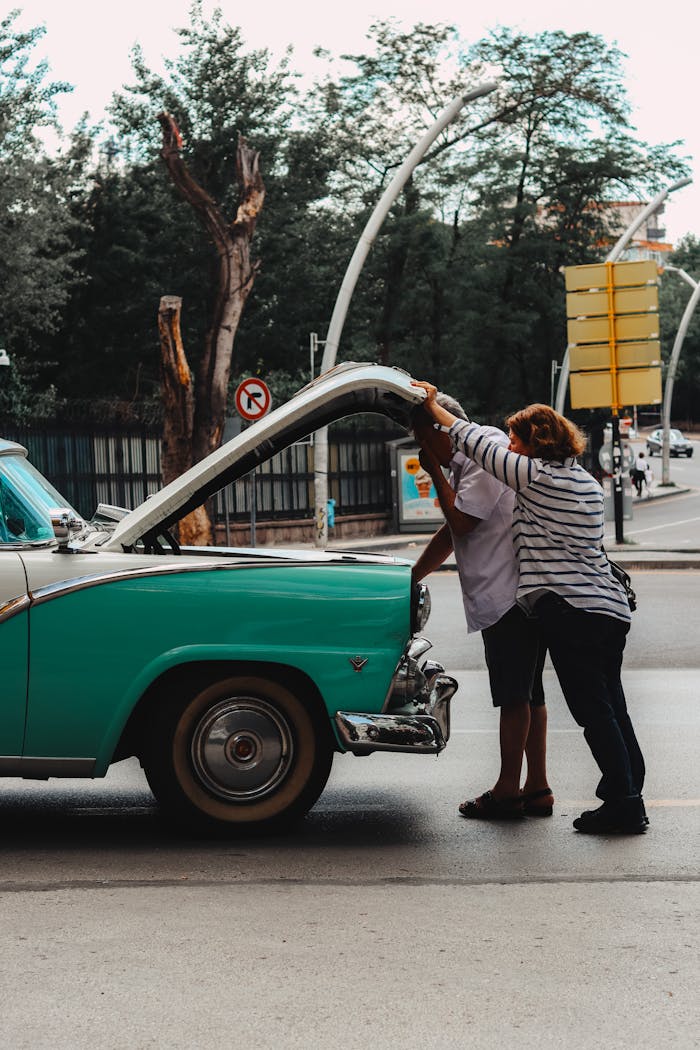 A couple examines a classic vintage car breakdown on an Ankara street.